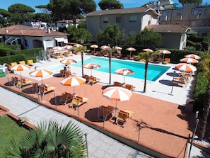 Una piscina al aire libre de temporada, sombrillas