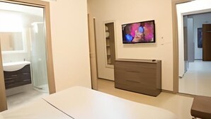 A bedroom with a bed, a dresser, a TV, and a mirror. - IMHOME - Cadorna House (Milan)