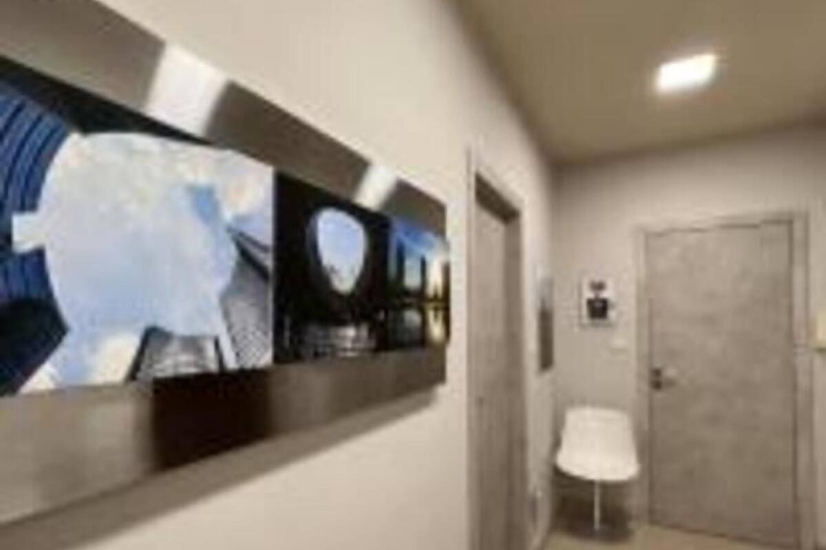 A hallway with a modern art display, a door, and a small table.