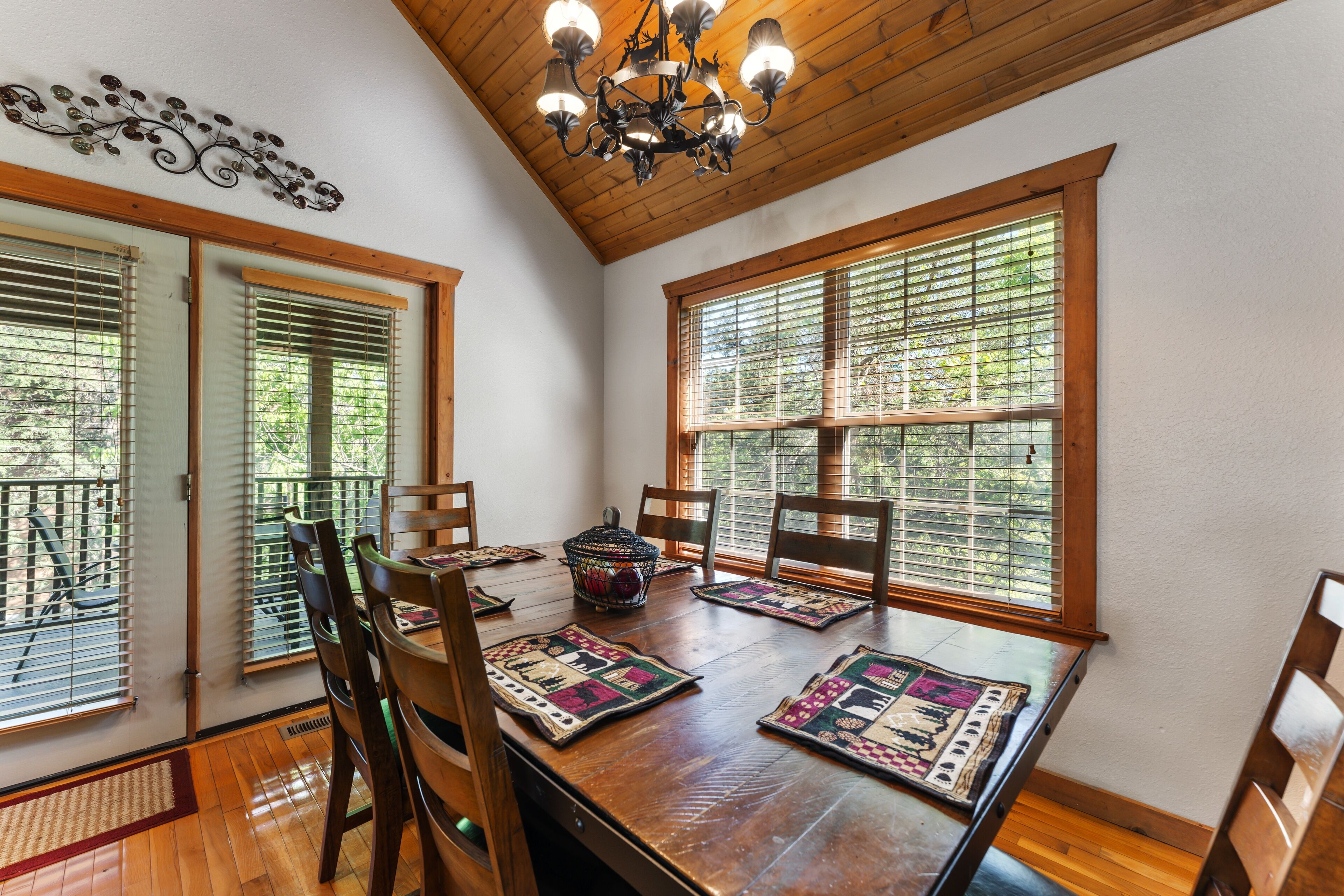 A dining area with a wooden table, chairs, and a chandelier.