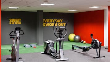 Ein Fitnessraum mit Ergometer, Crosstrainer und Rudergerät.