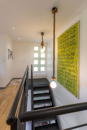 A staircase with a handrail, a hanging light fixture, and a wall with handwritten notes. - Emma's Villa in Crots (Crots)