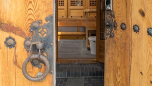 Una puerta de madera con herrajes metálicos y un tirador de anillo.