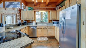 Una cocina con armarios de madera, un refrigerador de acero inoxidable, un microondas y un lavavajillas.