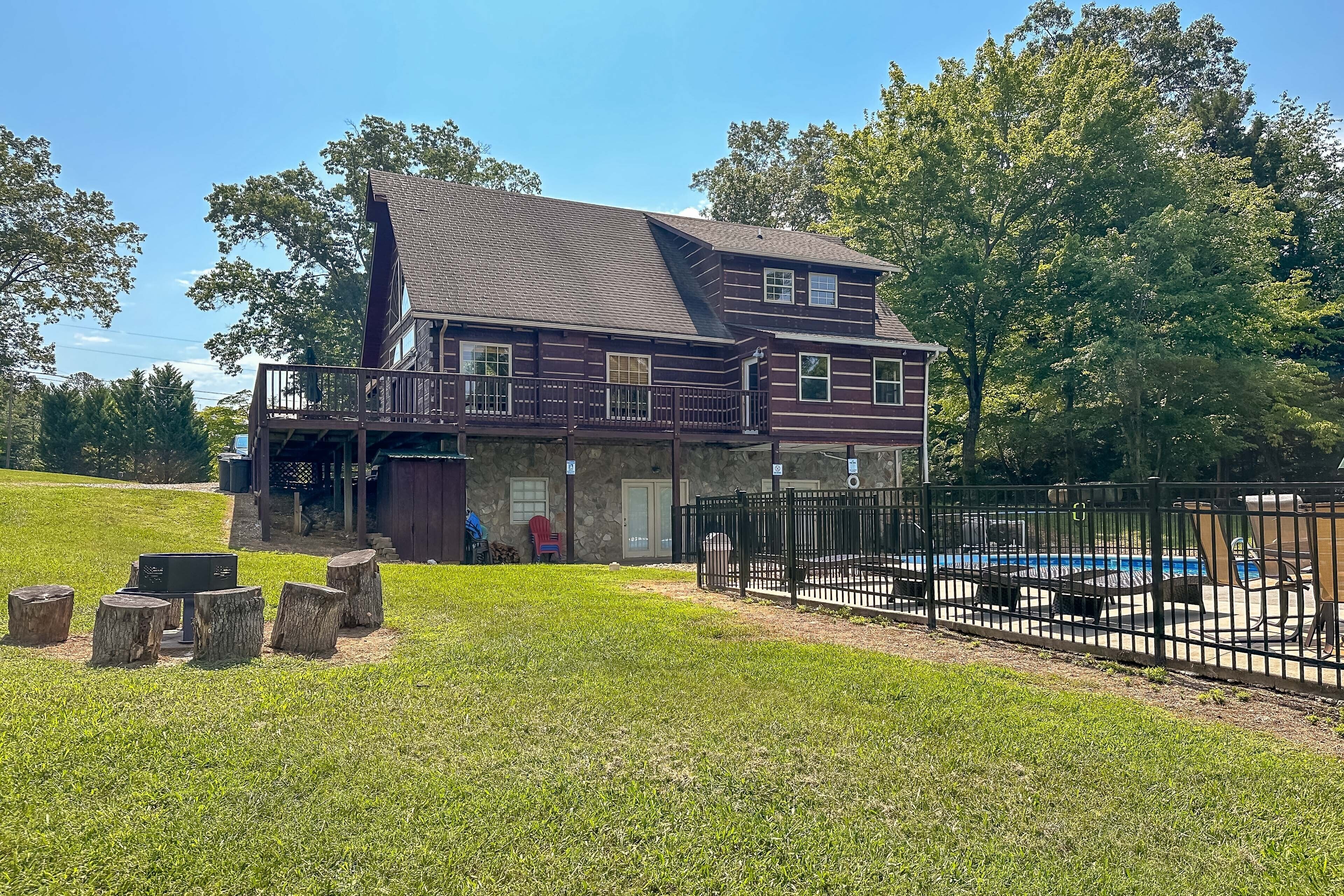 A two-story house with a balcony, a fenced yard, and a swimming pool.
