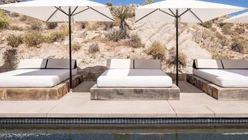 Relax by the pool with comfortable lounge chairs and umbrellas.