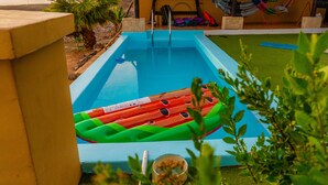 A swimming pool with a green and red inflatable raft. - Twin Fin Surf Camp - Hostel (Adeje)