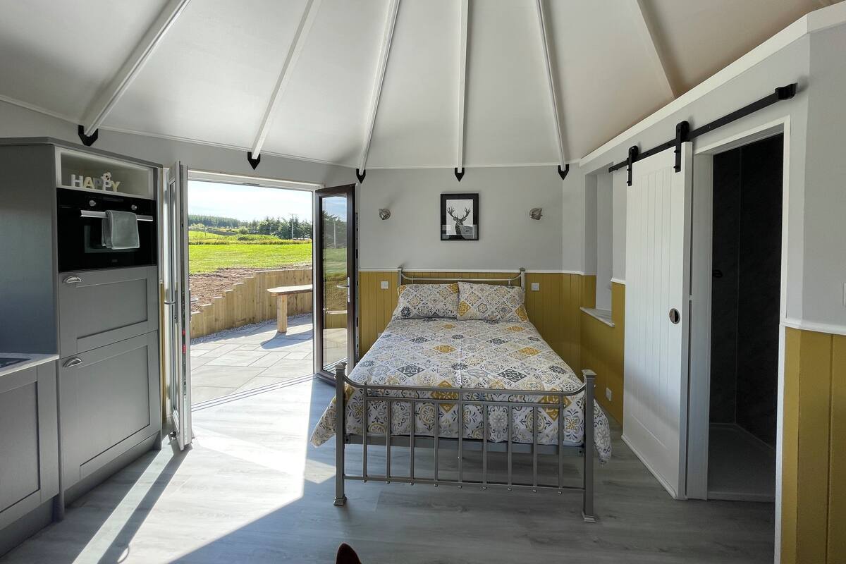 Alojamiento con tienda de campaña, cama, kitchenette y vistas al exterior.