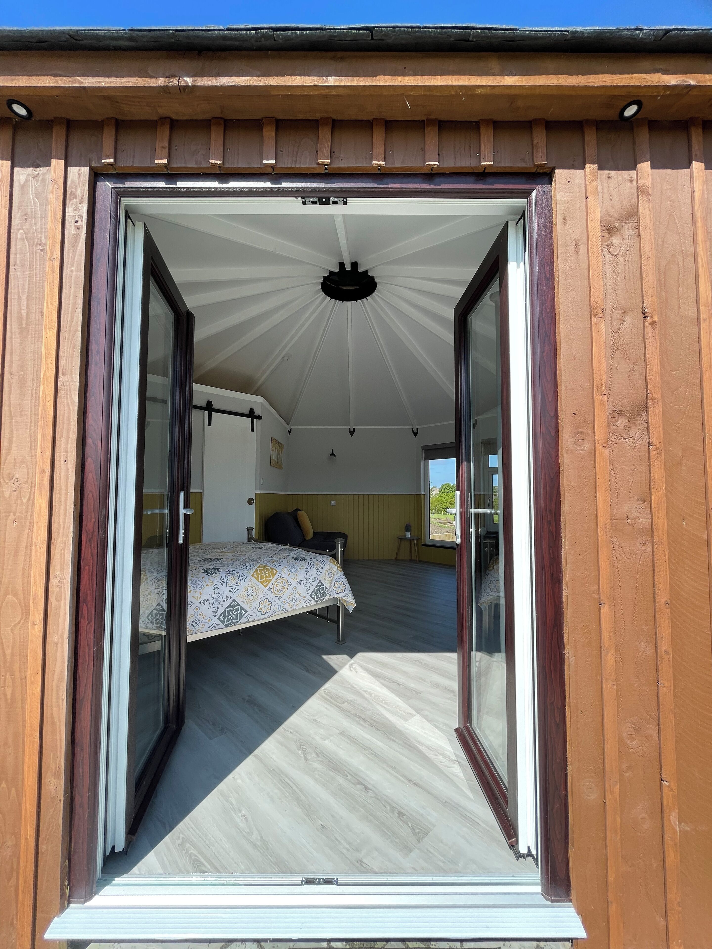 A bedroom with a bed, a small table, and a window.