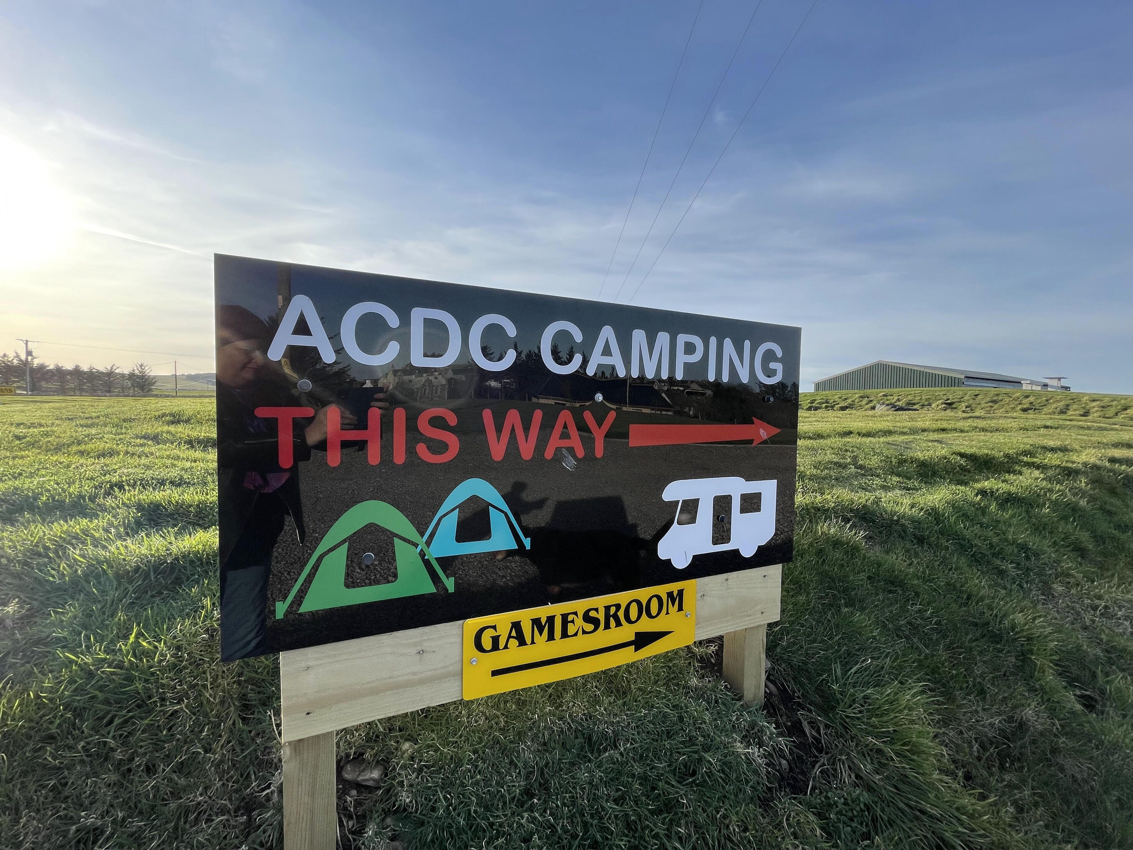 A sign for ACDC camping with directions to the gamesroom.