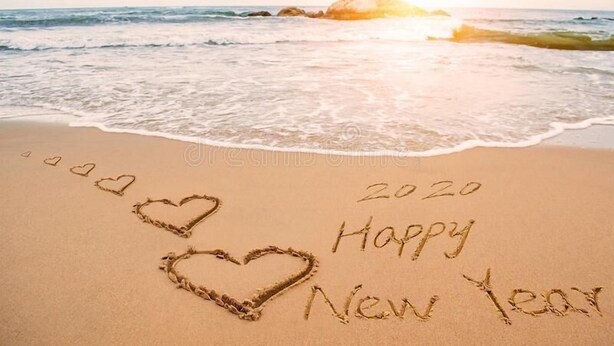 Una playa con arena y agua, con el año 2020 y la frase 'Happy New Year' escrita en ella.