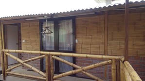 Un edificio de madera con una valla de bambú al frente.