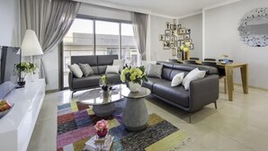 Ein modernes Wohnzimmer mit Sofa, Couchtisch und Essbereich.