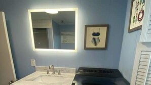 Une cuisine de taille réduite, équipée d’une cuisinière intégrée, d’un évier et d’un placard.