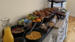 A breakfast buffet with various food items, a juice dispenser, and a coffee maker. - No 6 Bed & Breakfast (Landivy)