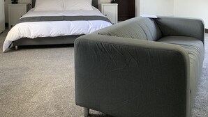 A bedroom with a bed, a chair, a nightstand, and a door. - No 6 Bed & Breakfast (Landivy)