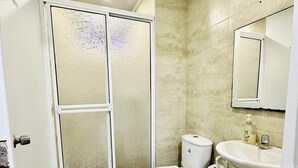 A bathroom with a toilet, sink, and shower. - Palmare House (San Andrés)