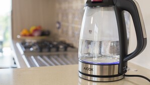 A kitchen with a water kettle on the counter.
