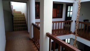 A multi-level interior with wooden railings, a staircase with patterned steps, and a white wall. - Hotel Rural Posada de los Santos (Ráquira)
