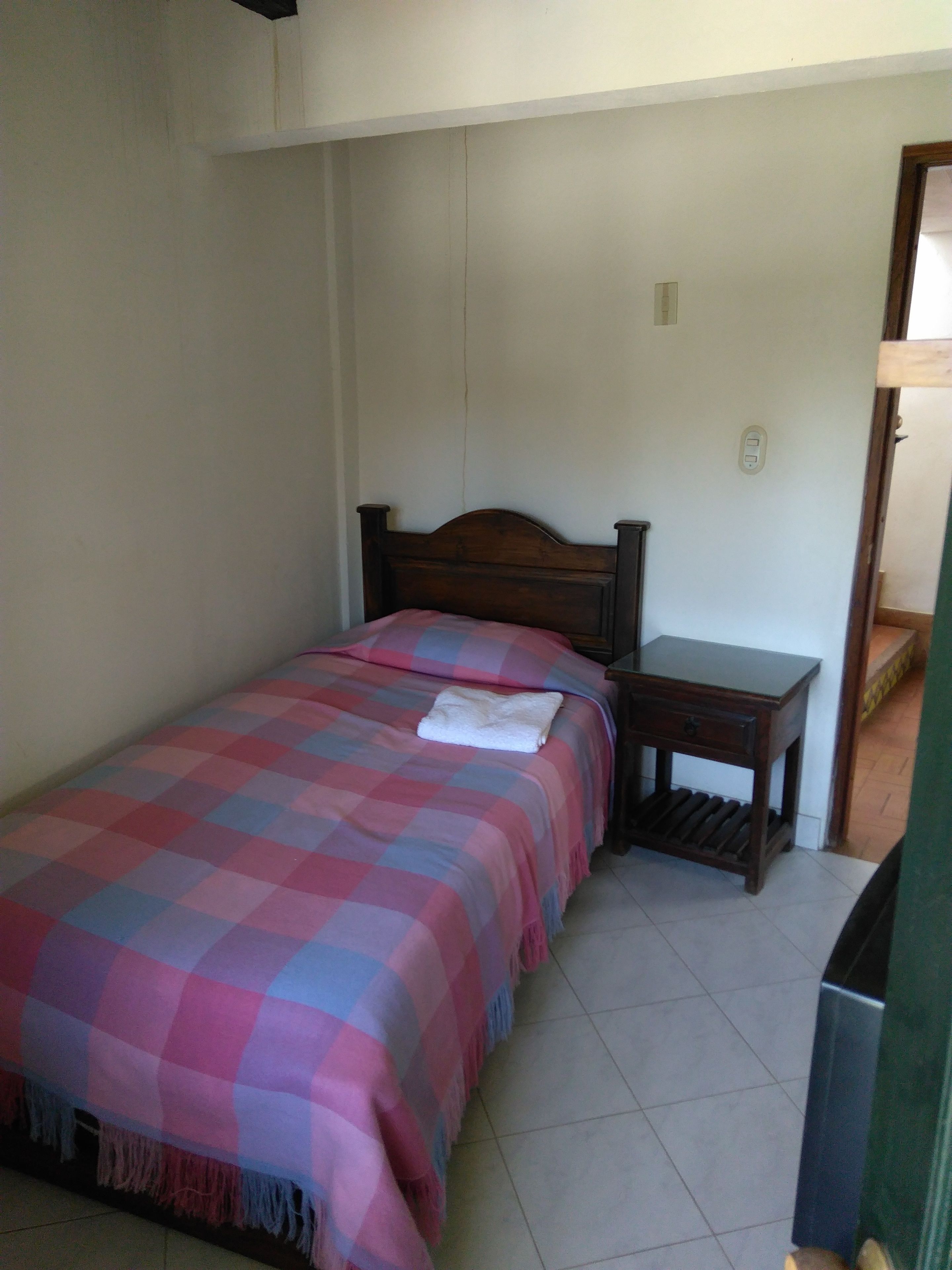Ein Schlafzimmer mit einem Bett, einem Nachttisch und einer Steckdose.