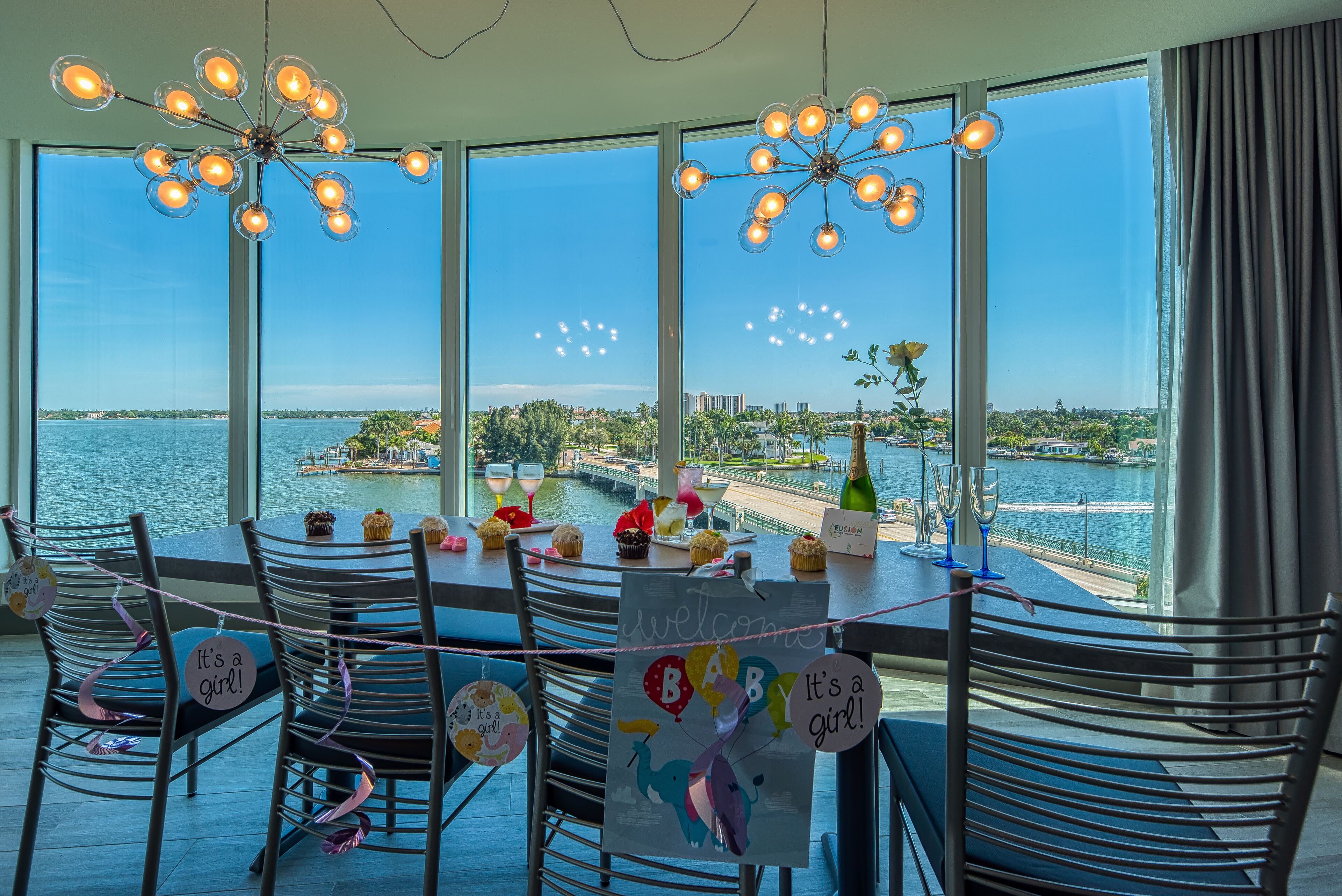 Un comedor con vista a un cuerpo de agua, decorado con globos y un cartel de 'Welcome'.