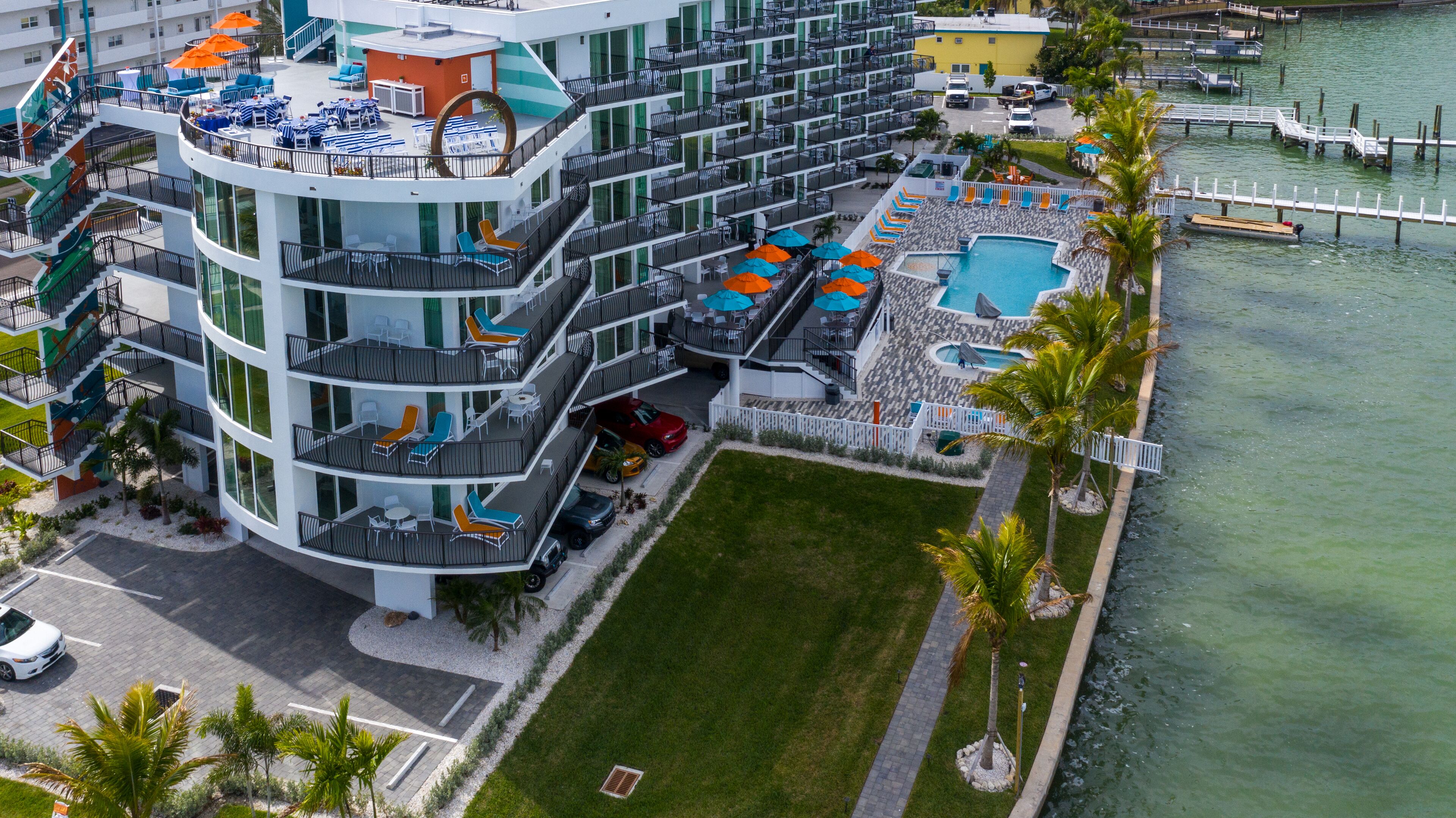 Un hôtel à plusieurs étages doté d’une terrasse, d’une piscine et d’un port de plaisance.