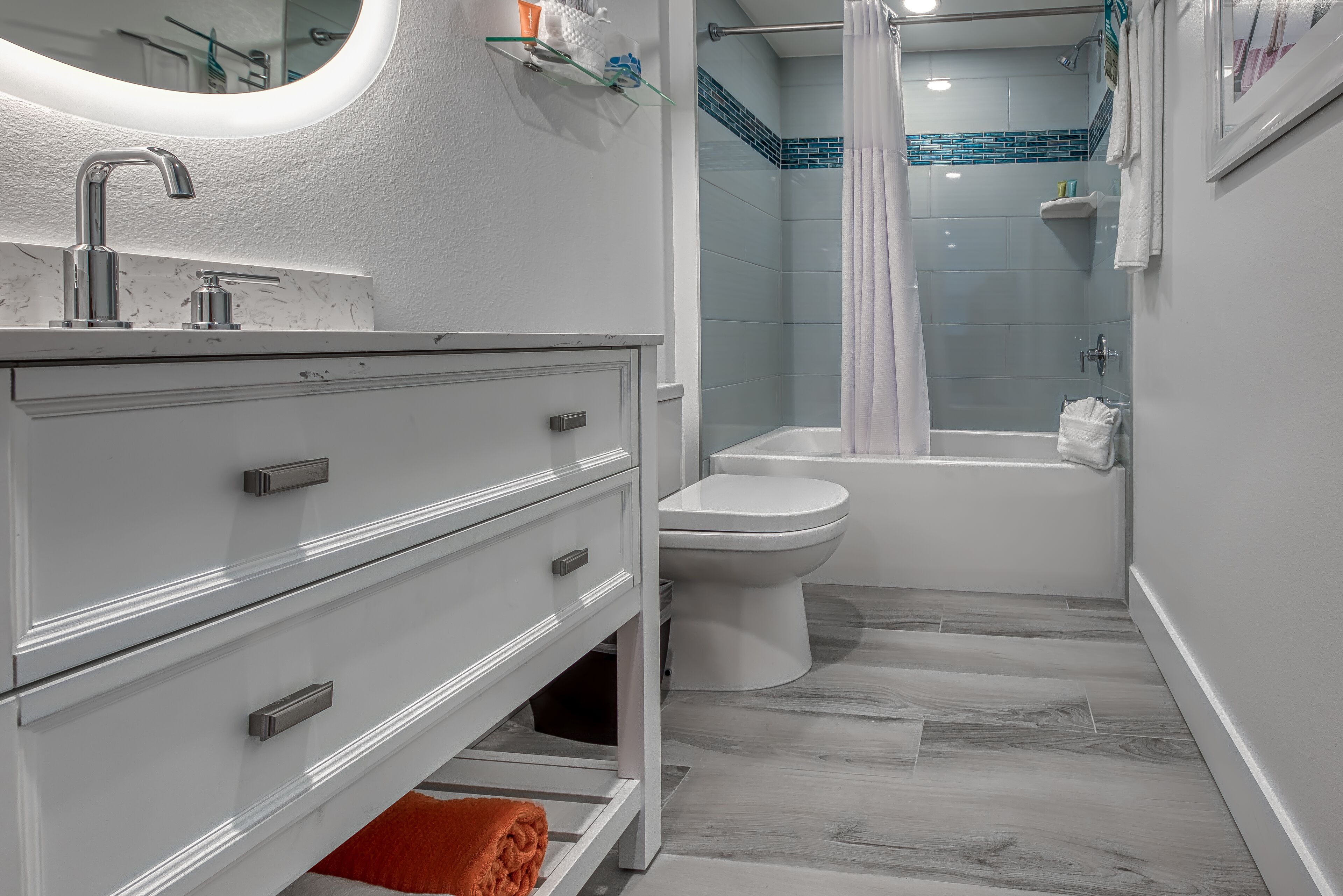 Un baño moderno con tocador blanco, lavamanos y retrete.
