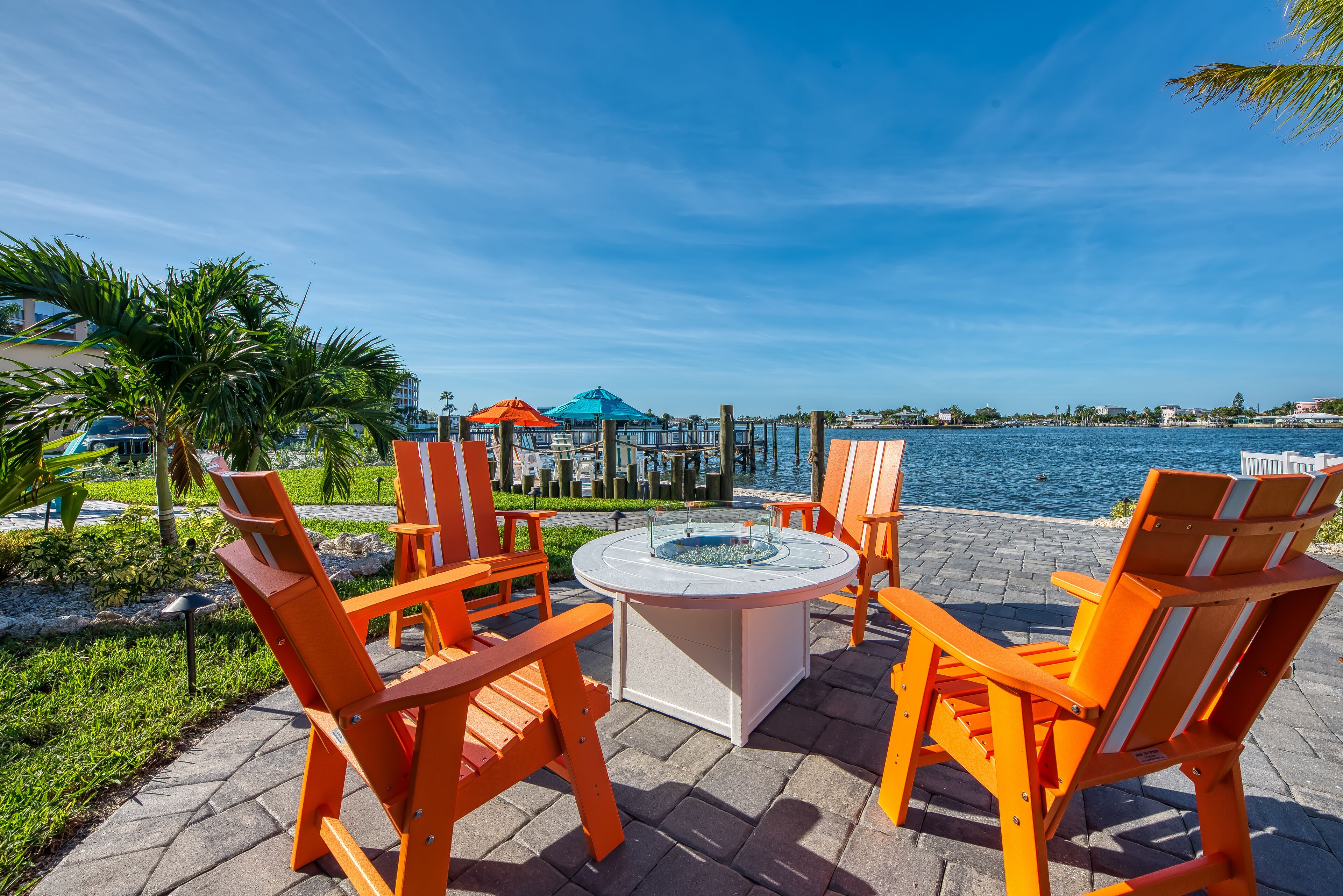 Outdoor seating with a view of the water and buildings in the background.