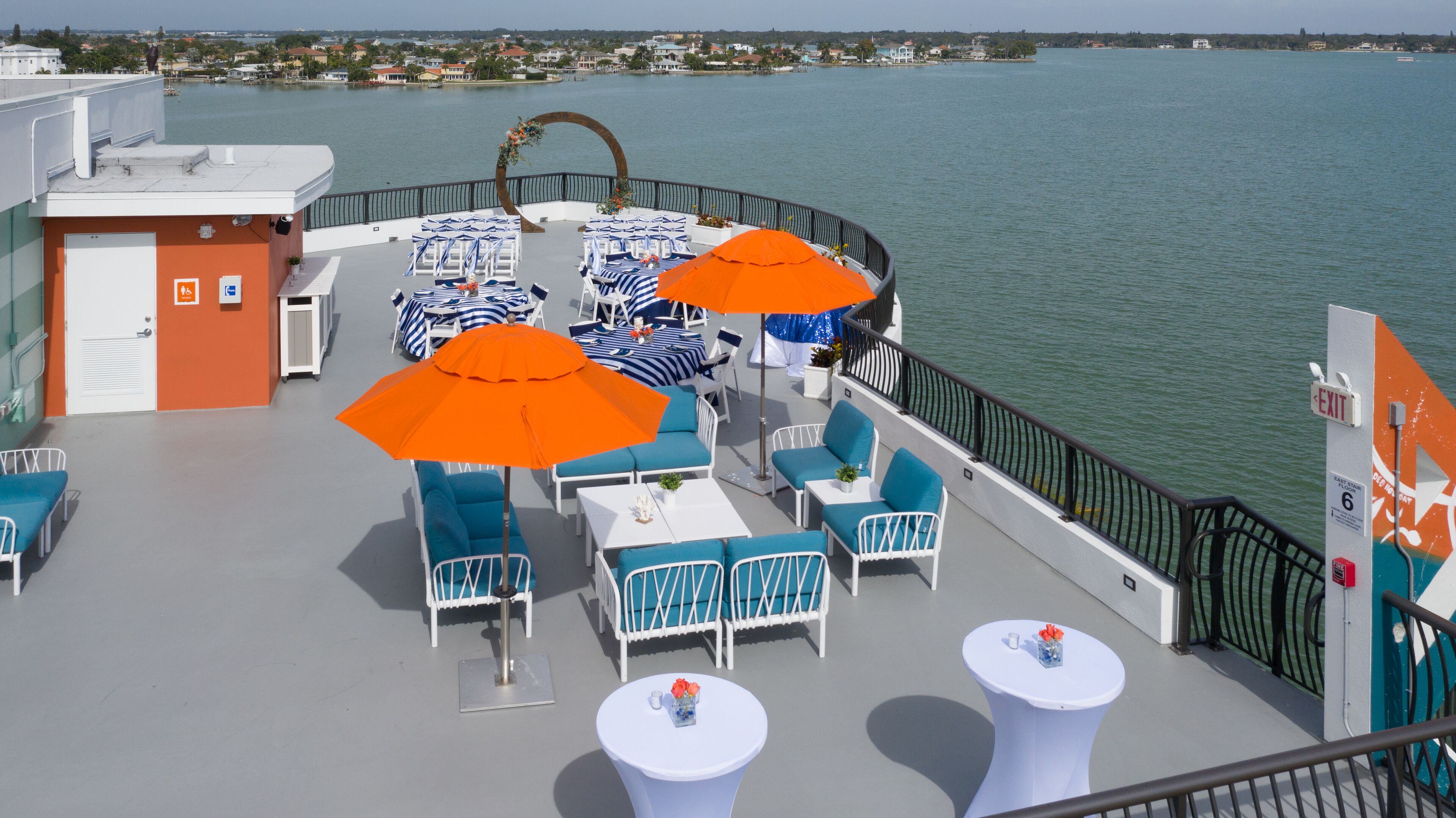 Une terrasse avec espace salon extérieur, comprenant des tables, des chaises et des parasols.