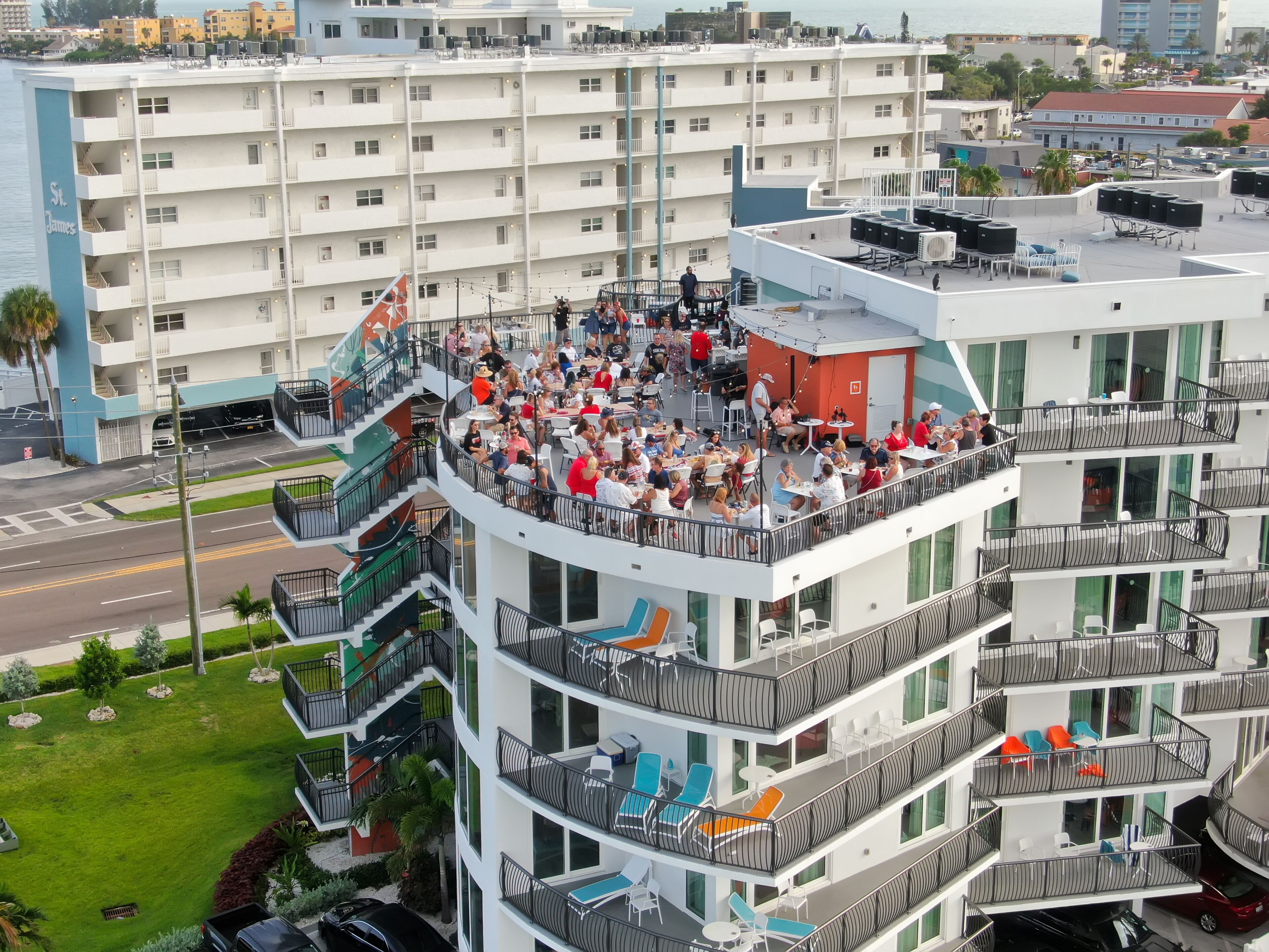 Un hôtel à plusieurs étages doté d’espaces extérieurs aménagés sur les balcons, offrant une vue sur le paysage urbain environnant.