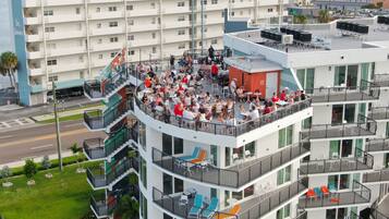 Un hôtel à plusieurs étages doté d’espaces extérieurs aménagés sur les balcons, offrant une vue sur le paysage urbain environnant.
