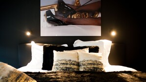 A bedroom with a large bed, a flat-screen TV mounted on the wall, and two bedside lamps. - Lord of Ghent Luxurious apartment in historical center of Ghent (Gent)
