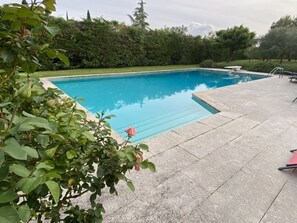 Ein rechteckiger Pool mit einer umlaufenden Steindeck.