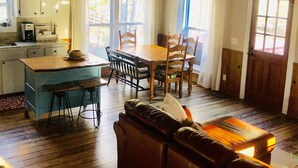 Une cuisine chaleureuse avec un coin repas, un plancher en bois et un ventilateur de plafond.