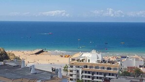 A coastal view with a beach, boats, and buildings.