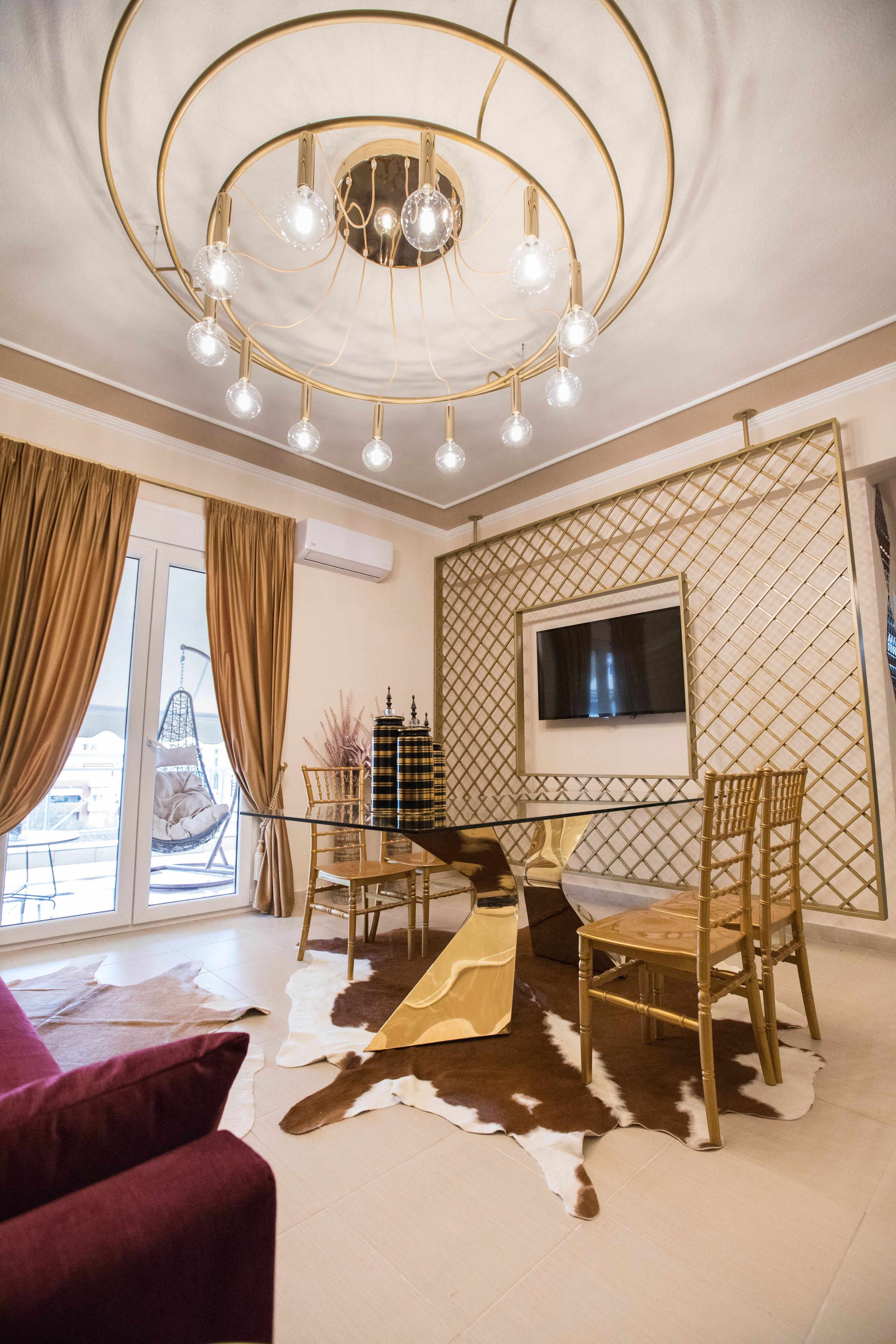 Un salon moderne agrémenté d’un lustre, d’un téléviseur fixé au mur et d’un tapis en peau de vache.