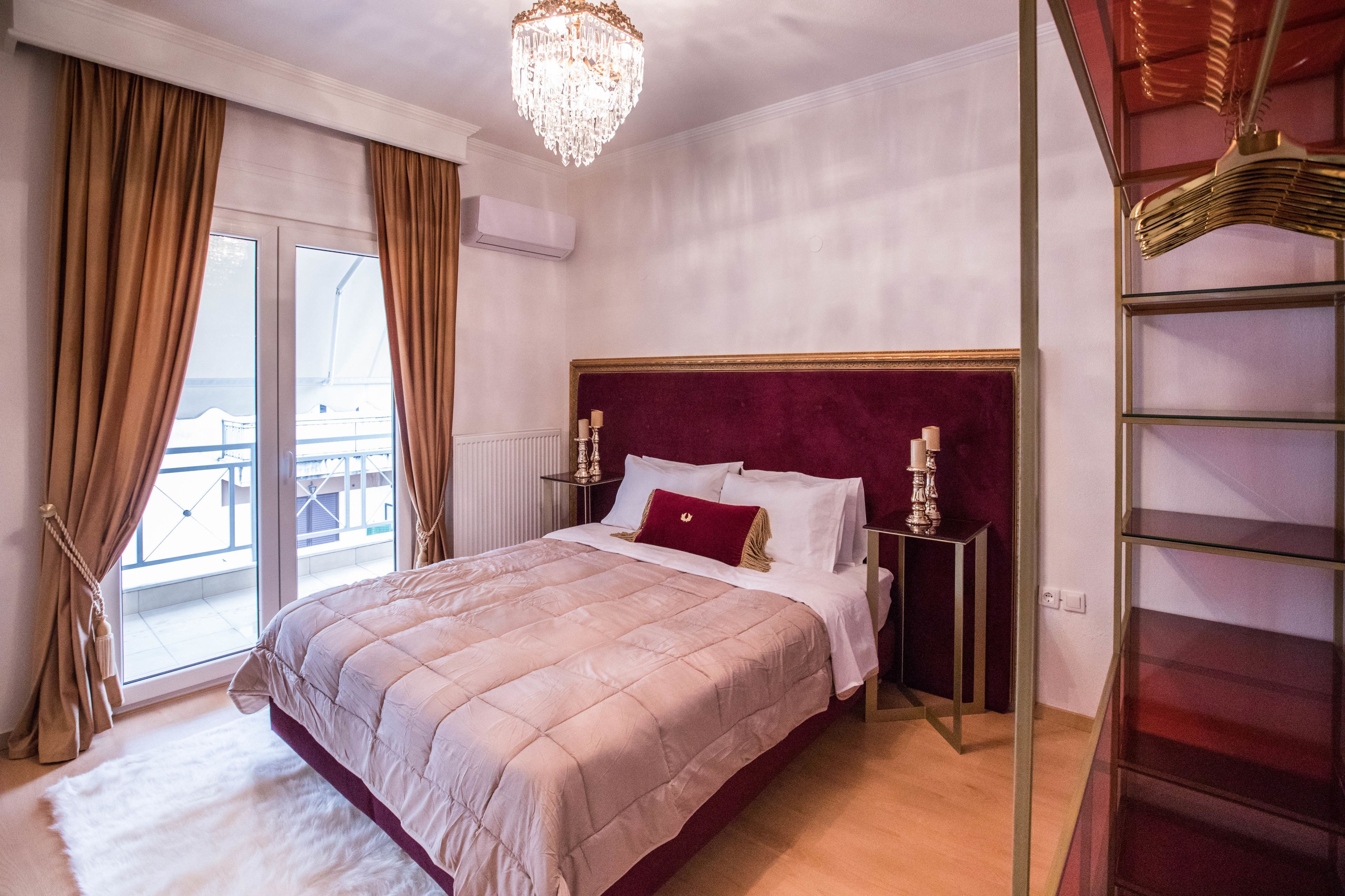 Una camera da letto con un grande letto, un lampadario e vista dalla finestra.