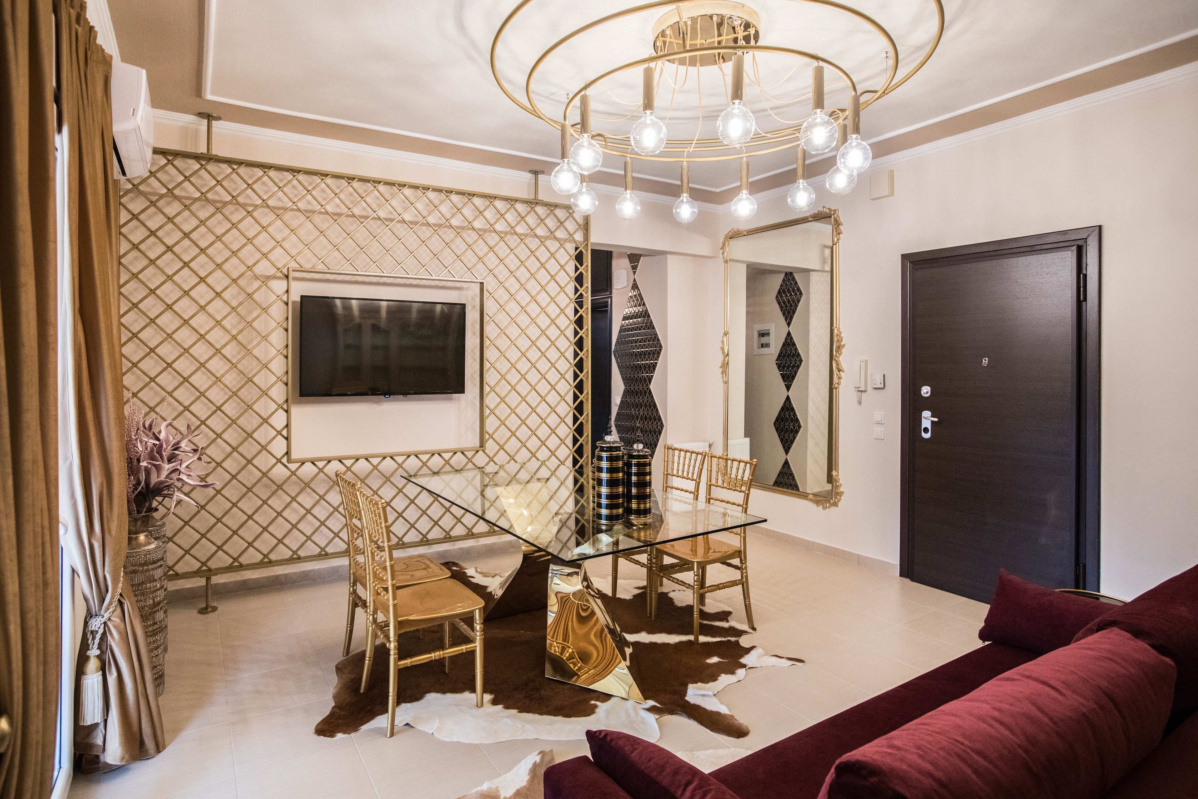 A modern living room with a glass table, leather sofa, and a chandelier.