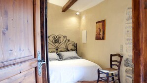 Ein Schlafzimmer mit einem Bett, einem Sessel und einem Bild an der Wand.