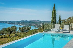 Una piscina con vista chiara sul mare e sulle colline.