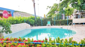 Una piscina al aire libre, sombrillas, tumbonas