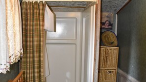 A bathroom with a sink, toilet, and shower curtain. - Historic Moose Lodge Cabin (South Fork)