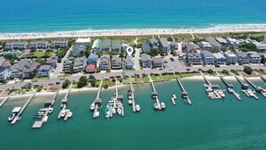Luftaufnahme einer Küstenwohngegend mit einer Marina, Strand und Reihenhäusern.