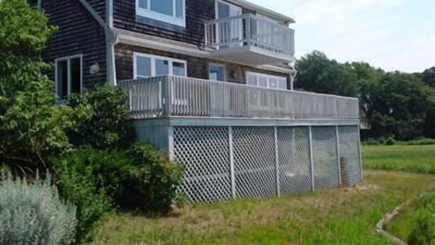 Une maison à deux étages dotée d’un balcon et d’une véranda.