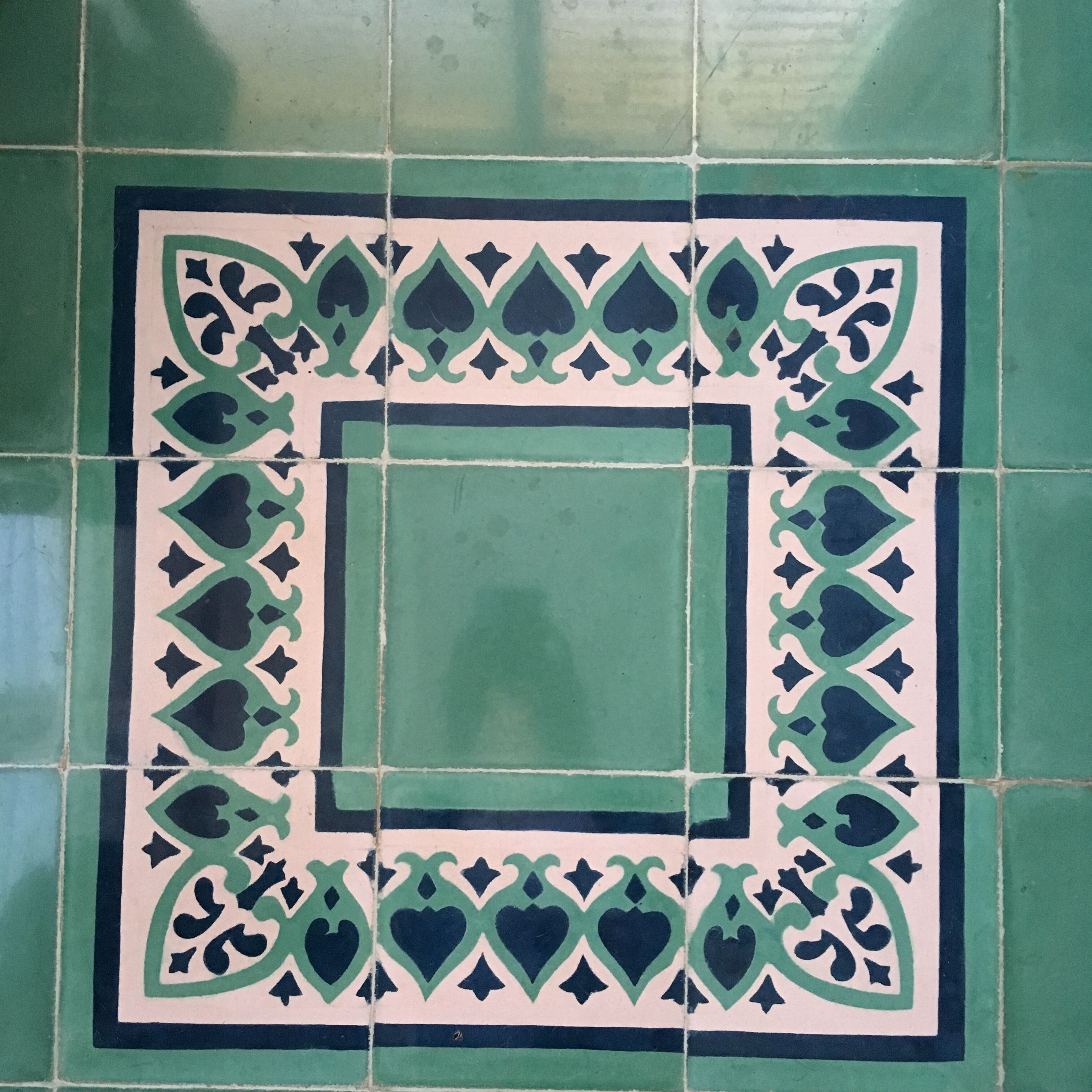 A square tile with a geometric pattern.