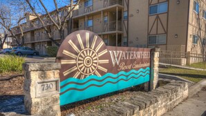 En skylt för Waterwheel Resort Condominiums, med en design som föreställer en sol och vågor.