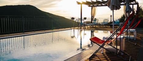 Seasonal outdoor pool, open 8:00 AM to 9:00 PM, pool umbrellas