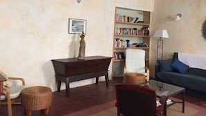 Un salon comprenant une bibliothèque, un canapé, une table basse et un ventilateur de plafond.