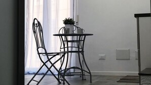Ein Zimmer mit Esstisch und Stühlen, einer Klimaanlage, einem Willkommensschild und einem Blumentopf.