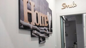 Ein Flur mit einem 'Home'-Schild und einem 'Smile'-Schild über einer Tür.